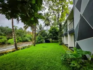 Lush green lawn and modern architecture overlooking a peaceful river.