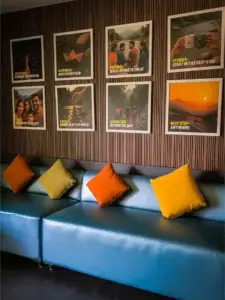 A cozy lounge area featuring vibrant seating and travel-inspired wall art.